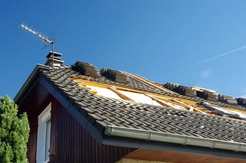 Toiture en cours de rénovation avec tuiles déposées, liteaux et écran sous-toiture apparents.